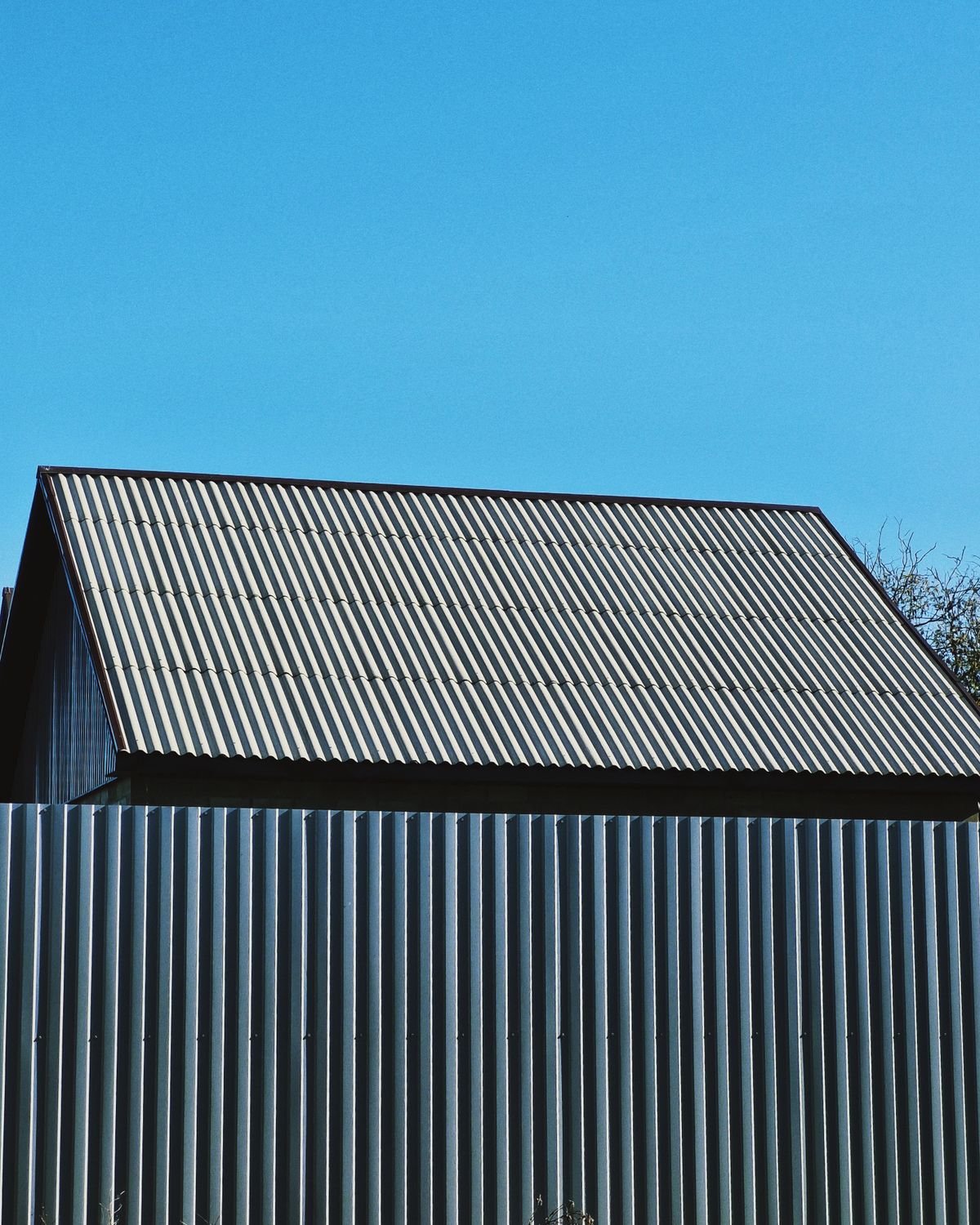 Corrugated metal sheet roof on a shed against a blue sky