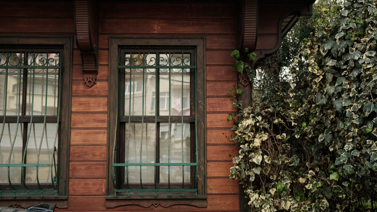 Traditional wooden windows with iron grills on a wooden house